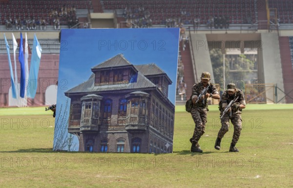 Personnel of the Central Reserve Police Force simulate an urban counter-terror operation, as they taking cover behind a mock building prop during a tactical drill at the 87th Raising Day celebrations, on February 19, 2026 in Guwahati, India