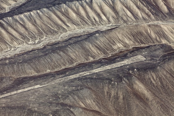 Aerial view of Nazca glyphs spanning sandy hills, the geoglyphs and paintings in the desert near Nasca and Palpa in Peru