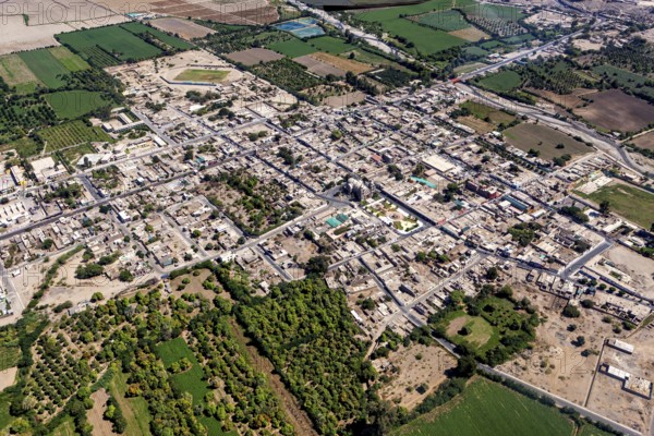 Aerial view of a city surrounded by green fields and clear road networks, The city of Nasca in Peru