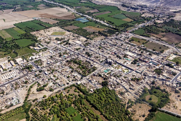 Aerial view of a city surrounded by agricultural land and a highly visible road network, The city of Nasca in Peru