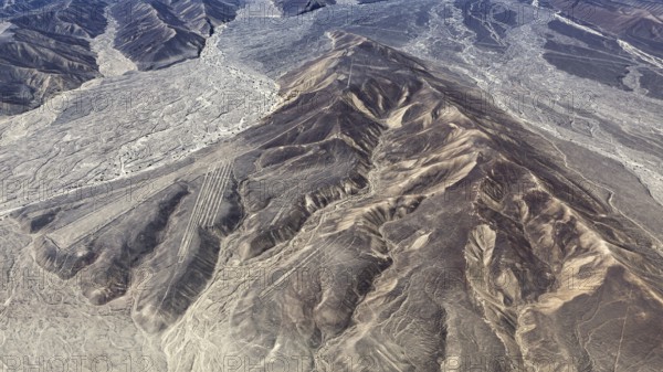 Mountain ranges in a dry desert landscape with clear geoglyph patterns, the geoglyphs and images in the desert near Nasca and Palpa in Peru