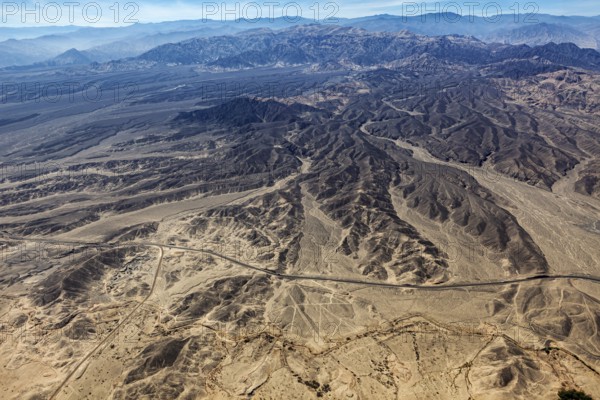 Wide and dry desert landscape with flat mountains and secluded roads, the geoglyphs and images in the desert near Nasca and Palpa in Peru