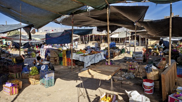 A quiet marketplace with stalls and boxes under shade, The market in the streets of Nasca in Peru