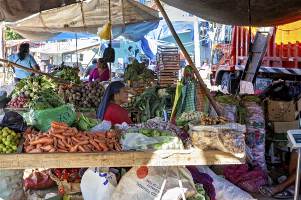 A busy street market with various vegetable stalls and people in a colorful environment, The market in the streets of Nasca in Peru