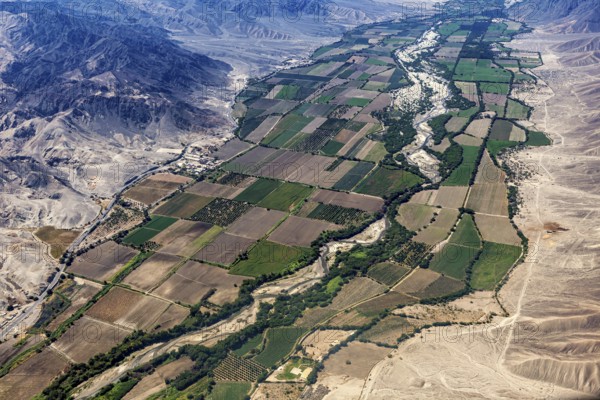 Green agricultural land and a river in the midst of a barren desert landscape, the desert landscape near Nasca in Peru