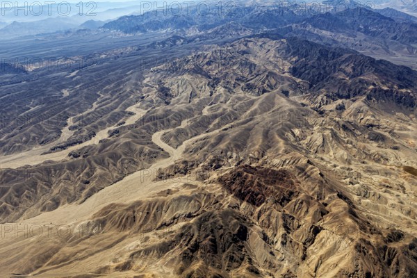 Extensive desert landscape with mountain ranges and sandy valleys from the air, The desert landscape near Nasca in Peru