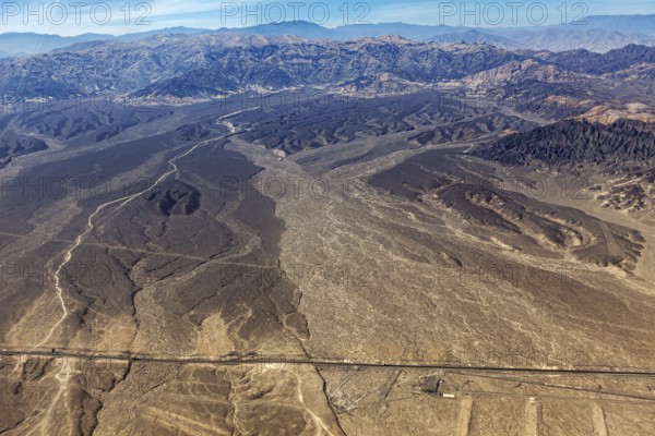 Extensive desert landscape with a long straight road, captured from above, The desert landscape near Nasca in Peru