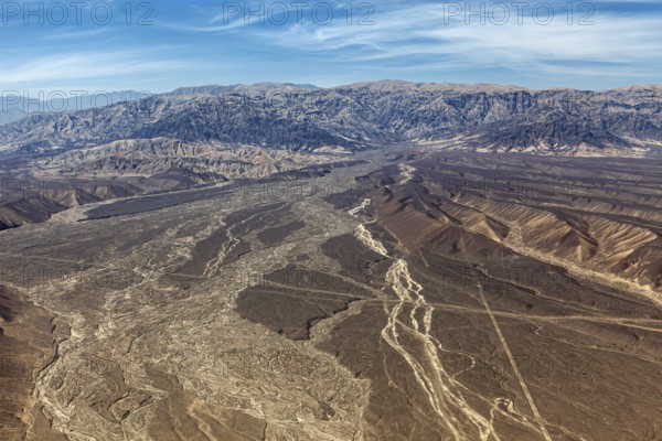 Barren desert plain with extensive mountains seen from a bird's eye view, the desert landscape near Nasca in Peru