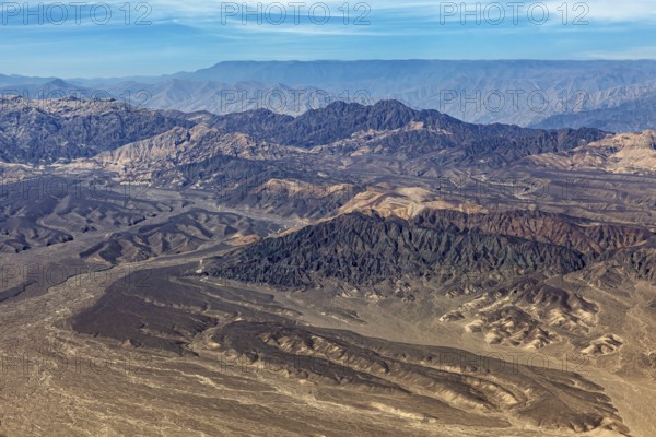Barren mountain landscape in the desert with various shades of brown taken from above, The desert landscape near Nasca in Peru