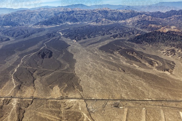 Extensive desert landscape with surrounding mountains photographed from a bird's eye view, The desert landscape near Nasca in Peru