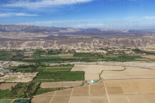 View of a mix of fields and dry landscapes with mountain range, The desert landscape near Nasca in Peru