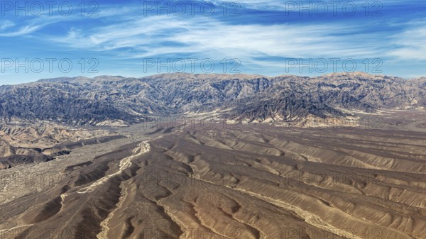 Landscape with dry desert area and mountain chain under blue sky, The desert landscape near Nasca in Peru
