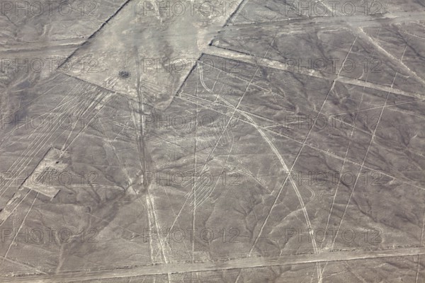 Geometric patterns and lines on a dry, brown desert soil, the geoglyphs and drawings in the desert near Nasca and Palpa in Peru