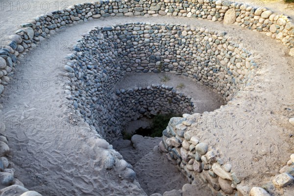 Deep spiral of stones winding into the ground, The ancient Nazca wells (puquios) near Nazca, Peru