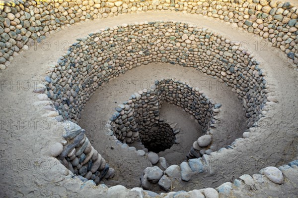 Stone spiral, which digs spirally into the ground, with evenly arranged stones, The ancient Nazca wells (puquios) near Nazca, Peru