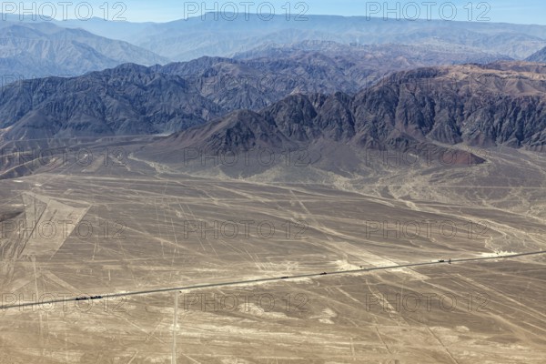 View of the Nazca Lines and surrounding mountains in a dry, barren landscape, the geoglyphs and images in the desert near Nasca and Palpa in Peru