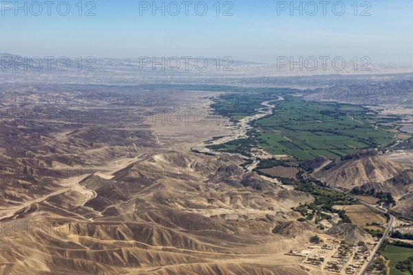 Wide desert-like landscape with a narrow green river valley in the foreground, the desert landscape near Nasca in Peru