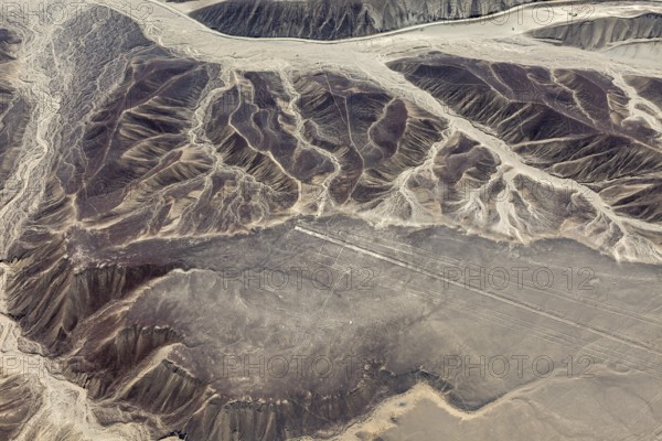 Erosion patterns and Nazca lines viewed from the air on a desert plateau landscape, the geoglyphs and images in the desert near Nasca and Palpa in Peru