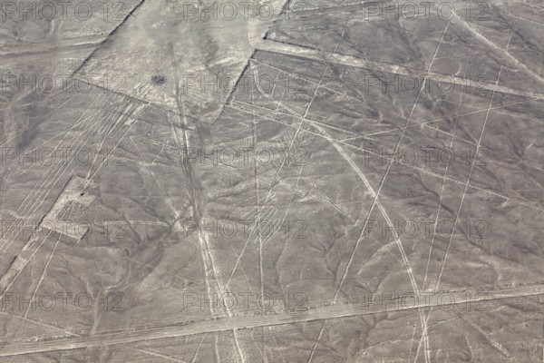 Aerial view of geometric figures in a dry desert landscape known as the Nazca Lines, the geoglyphs and drawings in the desert near Nasca and Palpa in Peru