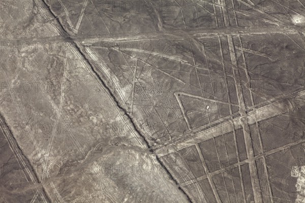 Geometric lines and patterns on a brown, dry desert surface, the geoglyphs and drawings in the desert near Nasca and Palpa in Peru