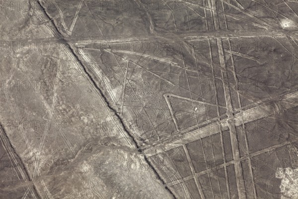 Aerial view of geometric lines on a barren desert landscape, the geoglyphs and images in the desert near Nasca and Palpa in Peru