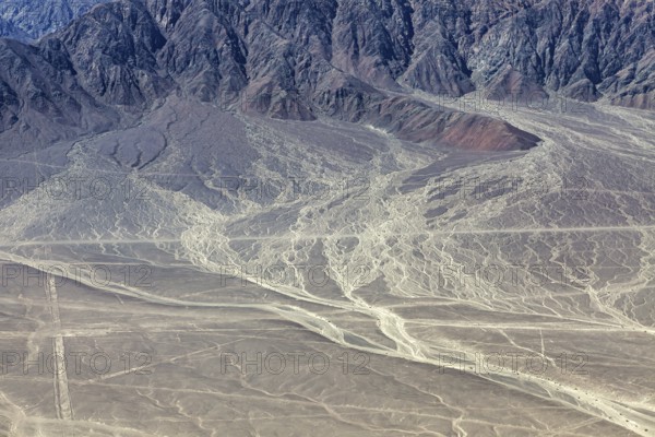 Erosion-prone desert landscape with rough mountain structures in the background, The desert landscape near Nasca in Peru