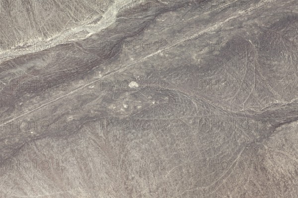 Aerial view of line patterns in a dry, sandy desert landscape, the geoglyphs and images in the desert near Nasca and Palpa in Peru