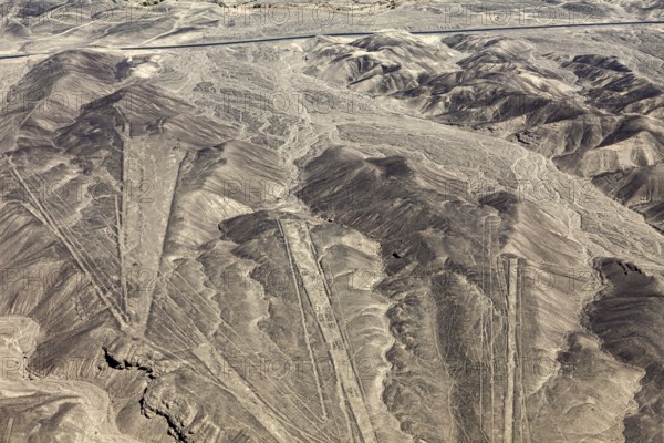 Extensive view of a desert region with geometric patterns in the mountains, the geoglyphs and drawings in the desert near Nasca and Palpa in Peru