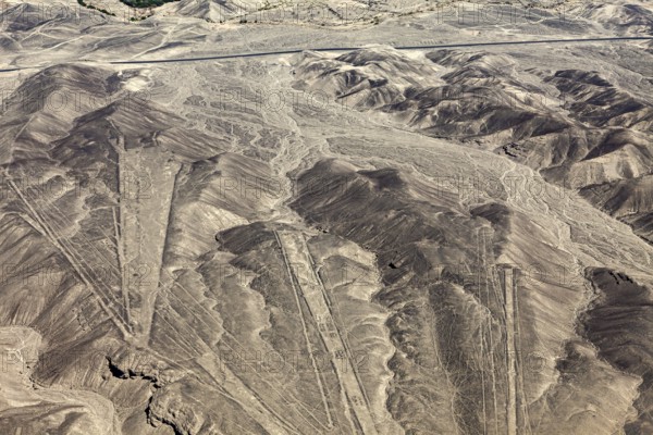 View of a dry desert landscape with clearly recognizable geoglyphs in the mountains, the geoglyphs and images in the desert near Nasca and Palpa in Peru