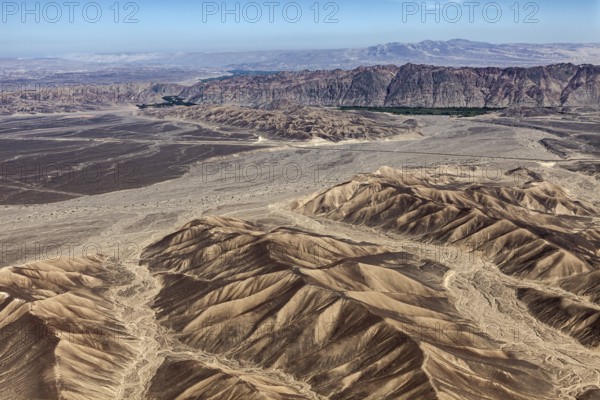 Wide desert landscape with sandy mountains and clear skies that accentuate aridity and vastness, The desert landscape near Nasca in Peru