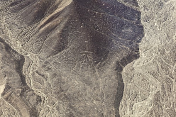 Geoglyphs and natural elevations in a dry, vast desert landscape, The geoglyphs and images in the desert near Nasca and Palpa in Peru