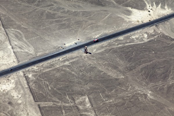 View of a road leading through a desert landscape with geoglyphs, the geoglyphs and paintings in the desert near Nasca and Palpa in Peru