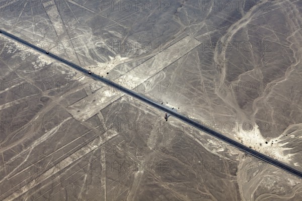 Aerial view of a road running through a desert landscape with lines, the geoglyphs and images in the desert near Nasca and Palpa in Peru