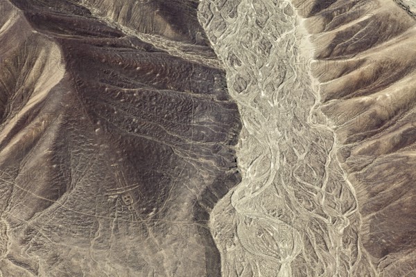 Aerial view of a hilly desert landscape with old patterns, geoglyphs and paintings in the desert near Nasca and Palpa in Peru