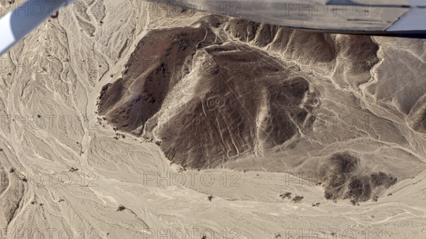 Aerial view of a desert landscape with geoglyphs and sandy hills, the geoglyphs and images in the desert near Nasca and Palpa in Peru