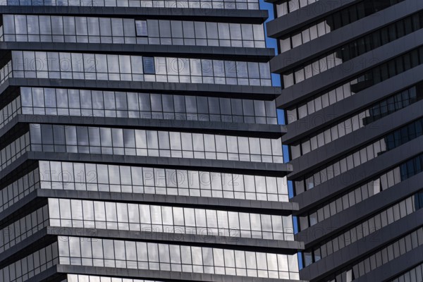 A detailed look at a modern skyscraper featuring geometric patterns formed by windows and reflections. The image captures the intricate design and reflects the contemporary architecture style