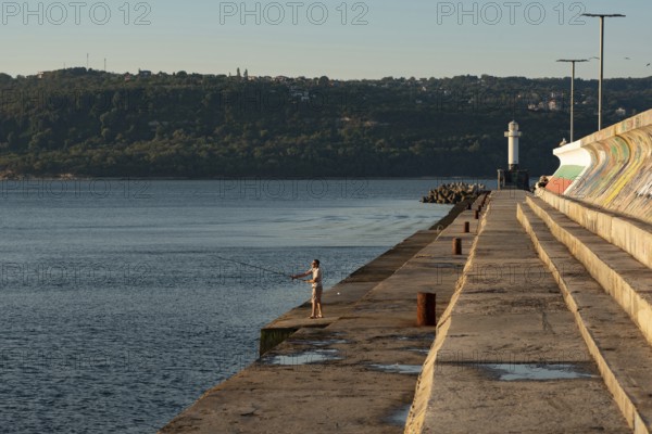 Varna, Bulgaria. September 5th 2020 A man fishing in the Black Sea near the Lighthouse at Varna Port, Bulgaria