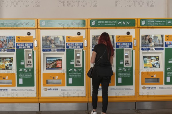 Budapest, Hungary. October 1st 2023 A woman buying a train ticket from an automatic machine at Nyugati Palyaudvar rail station in Budapest, Hungary