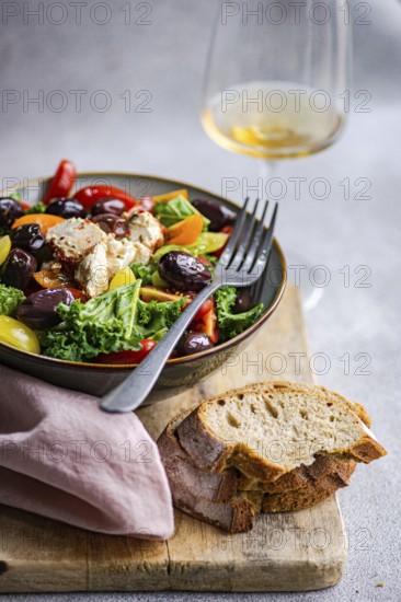 Salad features fresh raw kale, assorted cherry tomatoes, crisp red onion slices, BBQ olives, and spiced feta cheese, all drizzled with olive oil and served with sliced bread
