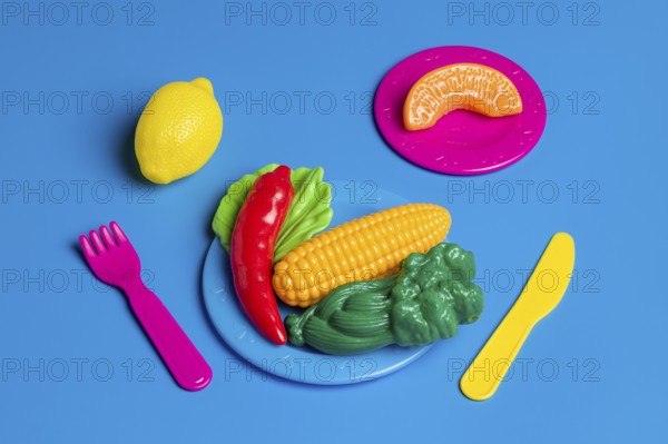 Colorful plastic food portrays junk food culture, critiquing modern diet trends Toys represent unhealthy eating habits and the artificiality of processed foods
