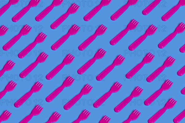 A vivid pattern of pink plastic forks on a blue background highlights the critique of junk food culture This playful yet poignant image symbolizes fast food's impact