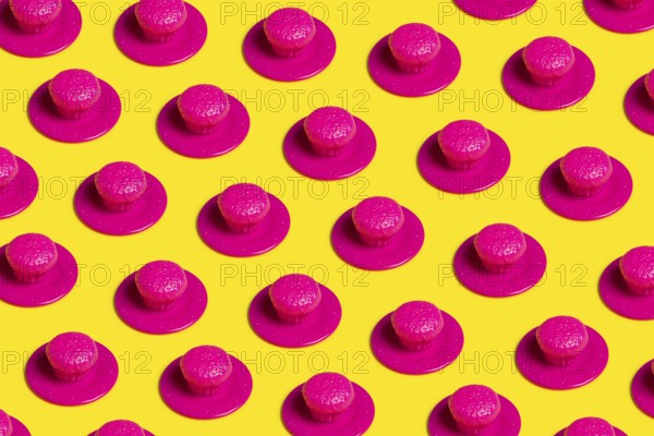 A vibrant pop art-style image featuring pink plastic cupcakes on yellow backgrounds, symbolizing the artificiality and excess of junk food and diet culture
