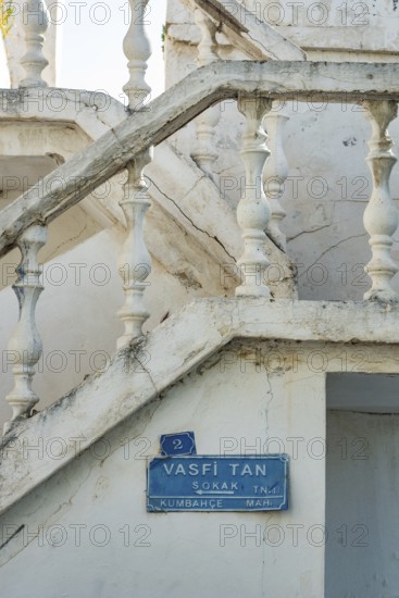 Bodrum, Mugla, Turkey. April 23rd 2022 Blue street sign for Vasfi Tan Sokak and traditional white painted stone balustrade in the alleys and side streets of Bodrum old Town, a popular tourism destination in western Turkey