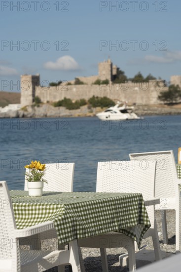 Bodrum, Mugla, Turkey. April 21st 2022 Pretty seaside cafe restaurant tables with table cloths and flowers overlooking Bodrum harbour on the western Aegean coastline of Turkey