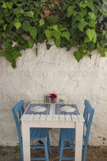 Pretty blue and white cafe restaurant table in a shaded side street in the popular tourist destination of Bodrum old town, Turkish Aegean coast of Turkey