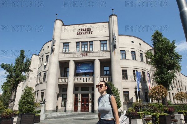 Belgrade, Serbia. July 23rd 2019 A pretty young Serbian girl walks past a soviet era building in Belgrade, Serbia