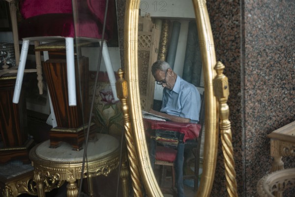 An old man sleeps inside a furniture shop during the summer heat of Alexandria, Egypt