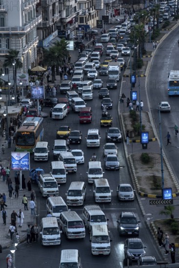Busy traffic with lots of public mini buses along the Mediterranean Sea front of Alexandria, Second largest city in Egypt