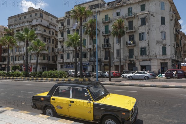 A black and yellow Alexandrian taxi parked along the Mediterranean Sea front Corniche, Alexandria, Egypt