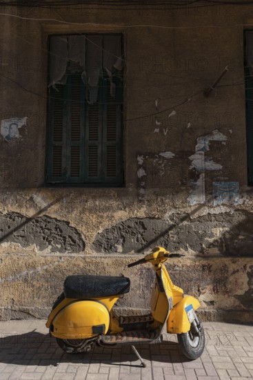 Trendy yellow motor scooter parked in a side street in the Mediterranean Egyptian city of Alexandria, Egypt